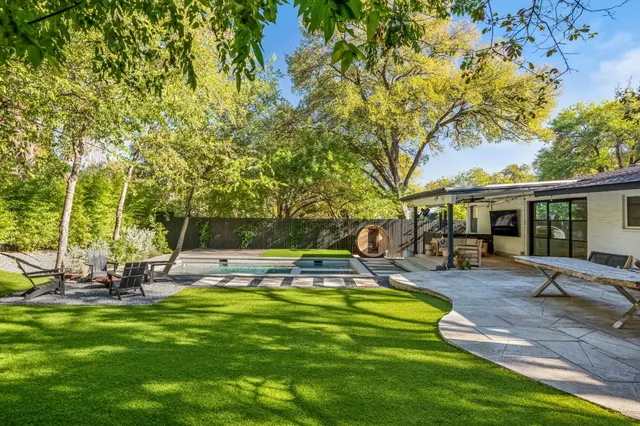 a swimming pool with outdoor seating and yard