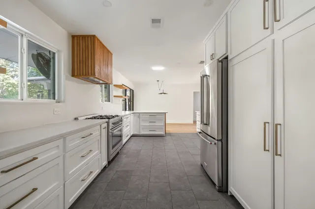 a kitchen with white cabinets and white appliances