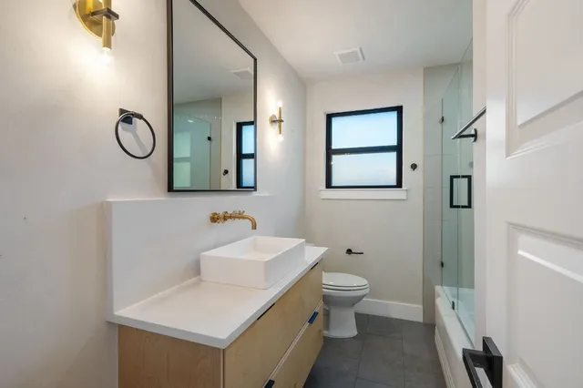 a bathroom with a toilet sink and mirror
