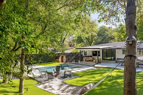 a view of a swimming pool with a patio and a yard