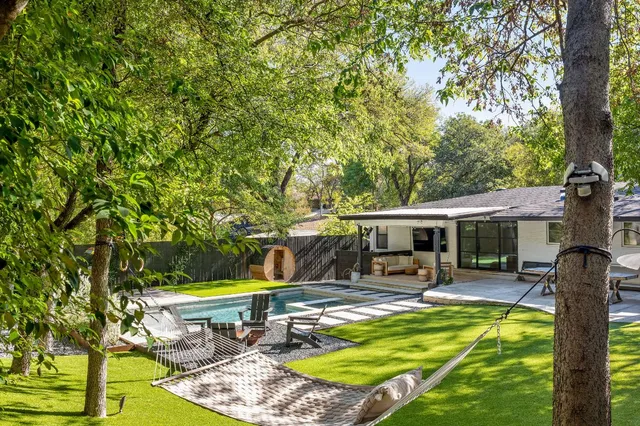 a view of a swimming pool with a patio and a yard