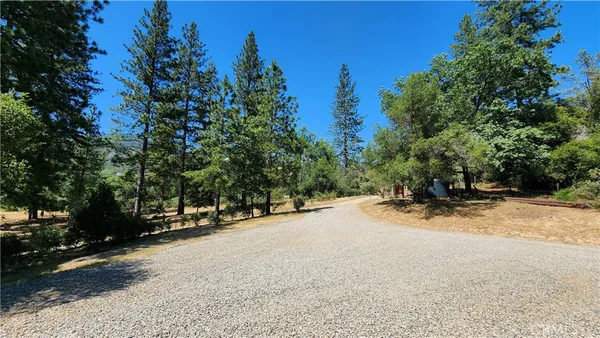 a view of house with yard and trees in the background