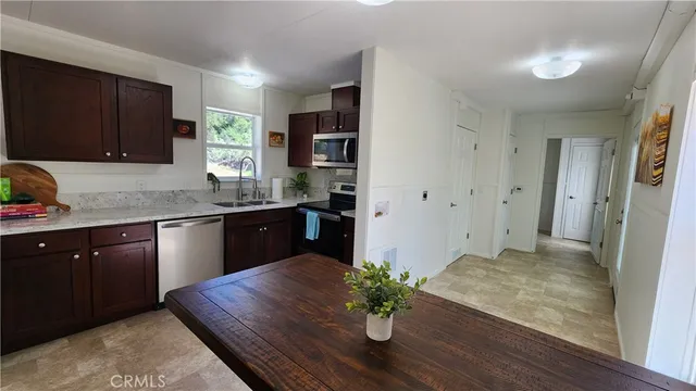 a kitchen with stainless steel appliances granite countertop a sink dishwasher stove and refrigerator