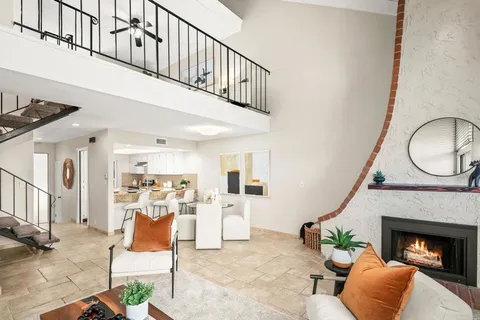a living room with furniture a fireplace and a chandelier