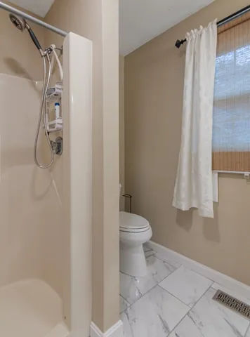 a bathroom with a toilet and a shower