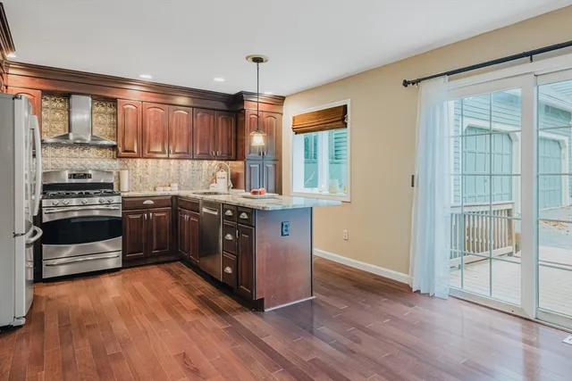 a kitchen with stainless steel appliances granite countertop a stove a sink and a refrigerator