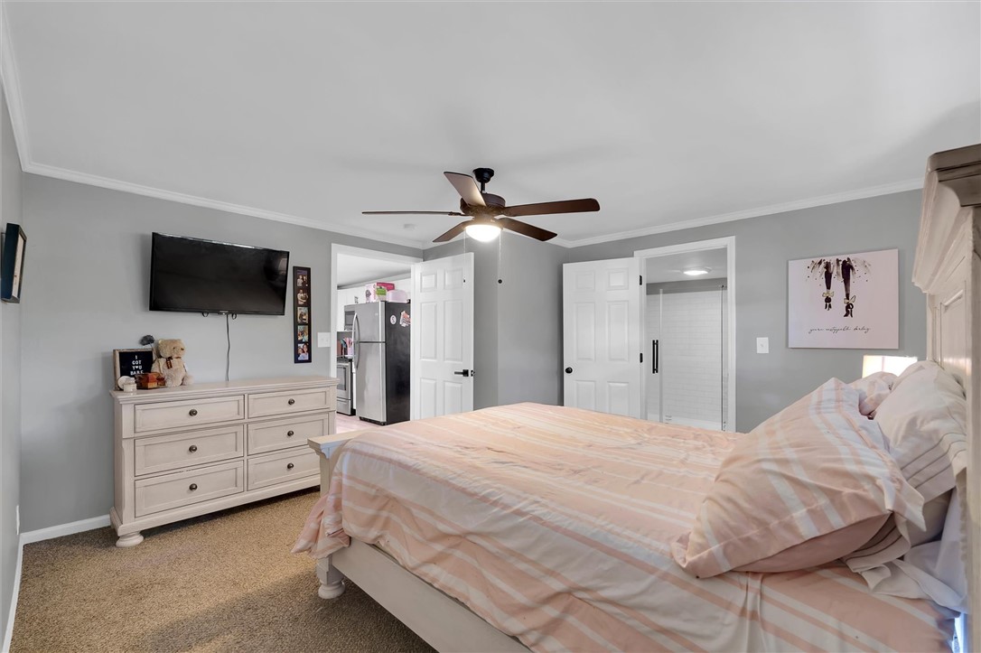115 May Street Easley, SC 29640 - Photo 12 of 25 Soft carpeting underfoot and clean crown molding frame this relaxing primary bedroom retreat.