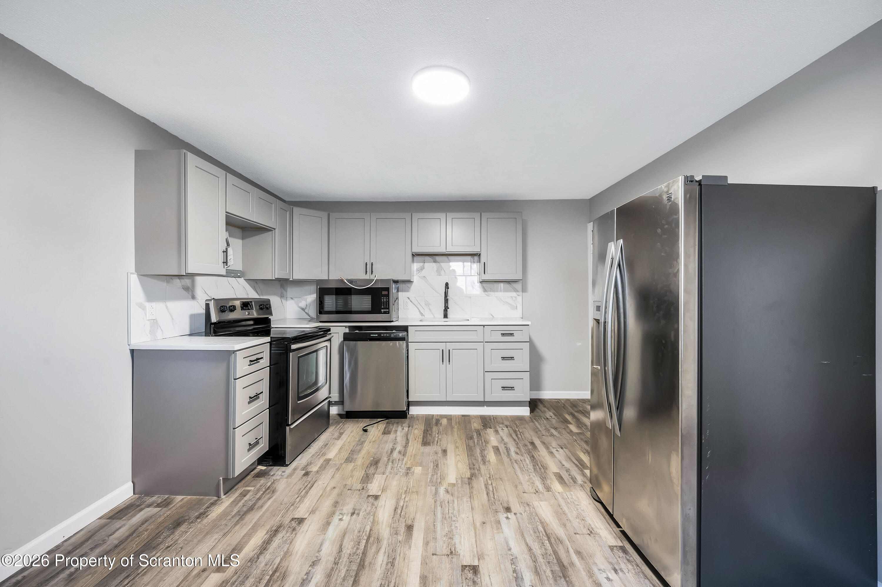 333 Oak Street, Unit 1/2 Scranton, PA 18508 - Photo 4 of 11 a kitchen with granite countertop a refrigerator stove top oven and sink