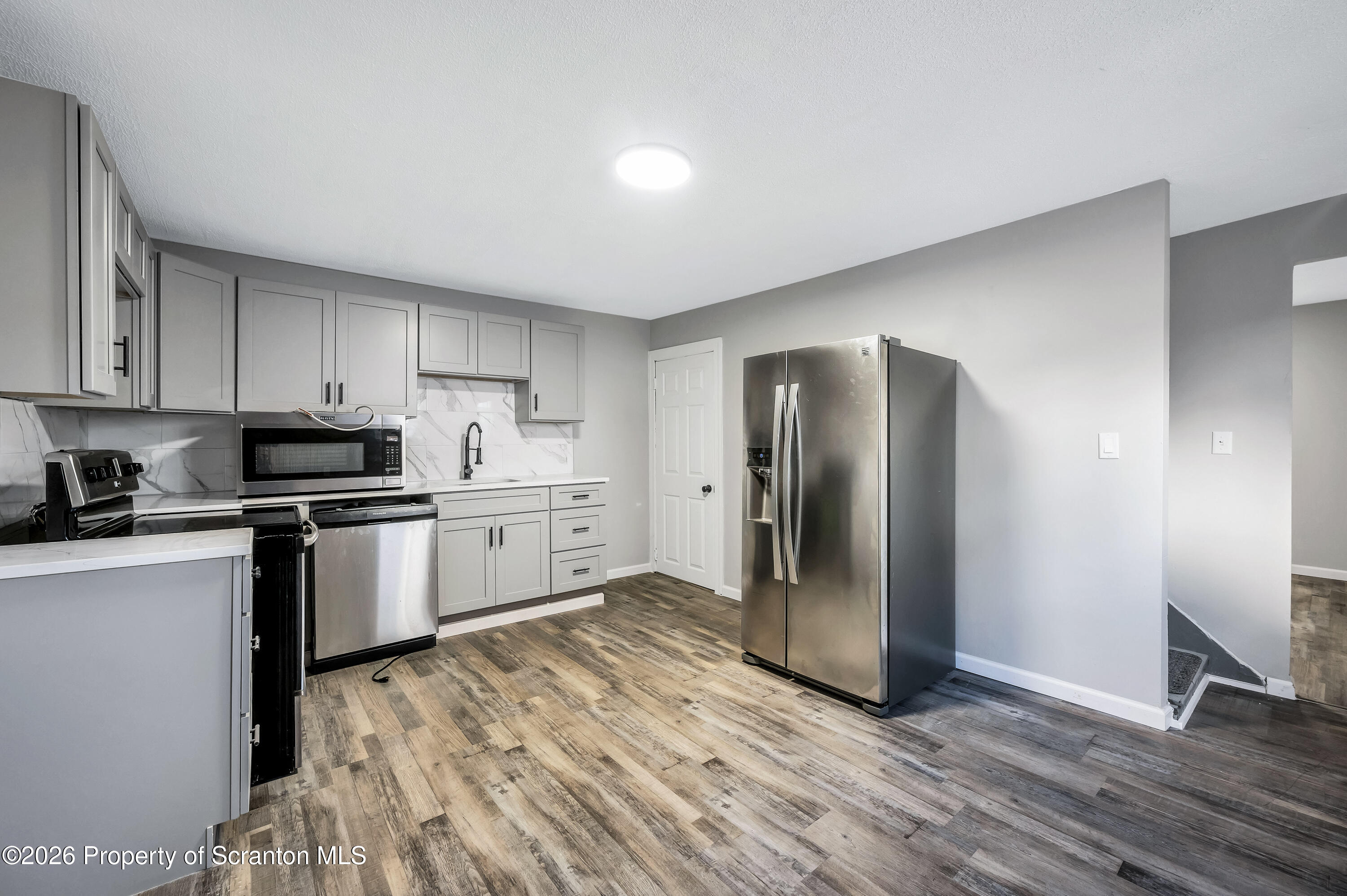 333 Oak Street, Unit 1/2 Scranton, PA 18508 - Photo 5 of 11 a kitchen with stainless steel appliances granite countertop a refrigerator and a stove top oven