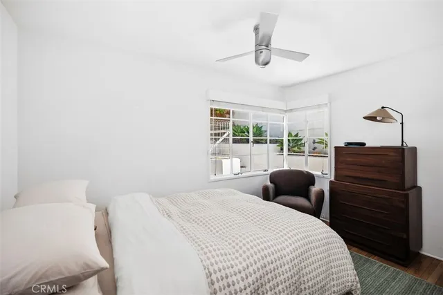 a bedroom with a bed a chandelier and a window