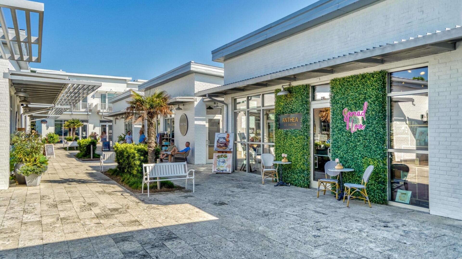 53 East E Pine, Unit A Inlet Beach, FL 32461 - Photo 56 of 59 a view of a patio with table and chairs potted plants and floor to ceiling window