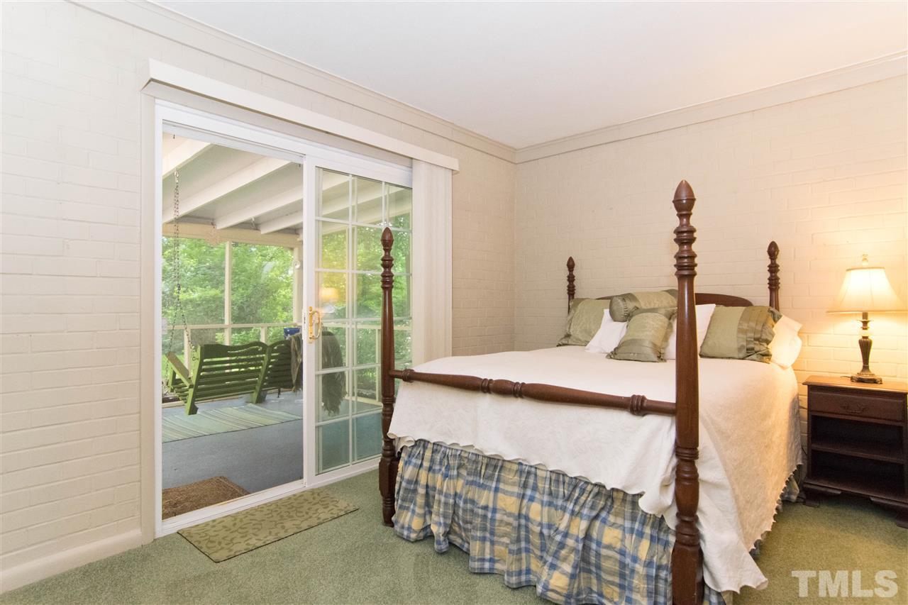 4708 Rampart Street Raleigh, NC 27609 - Photo 14 of 25 a bedroom with a bed and wooden floor