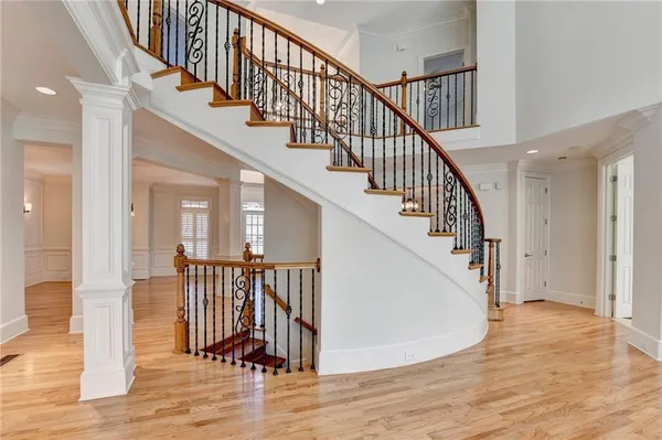 a view of staircase with wooden floor and a chandelier
