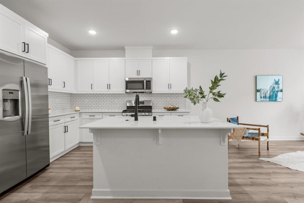 319 Minneola Place Fallbrook, CA 92028 - Photo 11 of 19 a kitchen with stainless steel appliances a sink a stove a refrigerator cabinets and a dining table