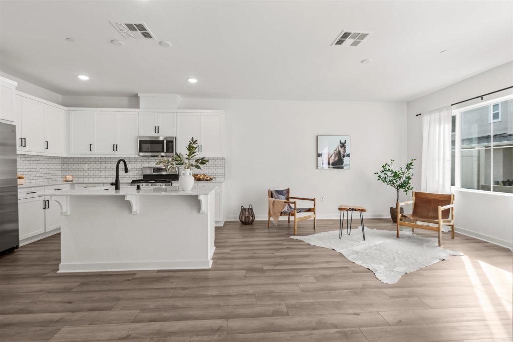 319 Minneola Place Fallbrook, CA 92028 - Photo 2 of 19 a view living room with stainless steel appliances granite countertop a stove top oven a dining table and chairs with wooden floor