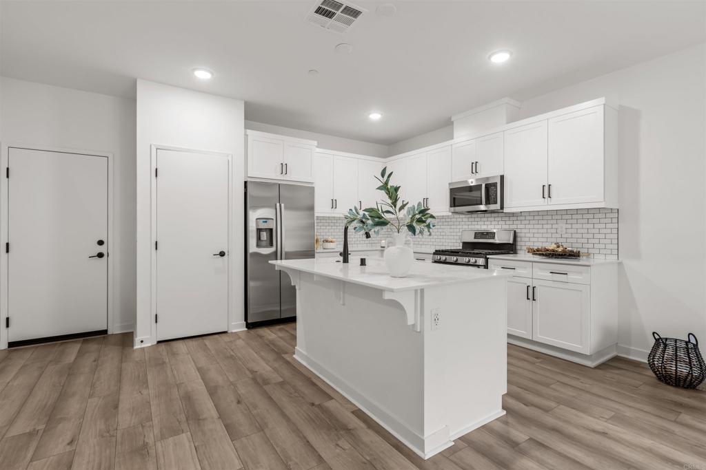 319 Minneola Place Fallbrook, CA 92028 - Photo 9 of 19 a kitchen with white cabinets and stainless steel appliances