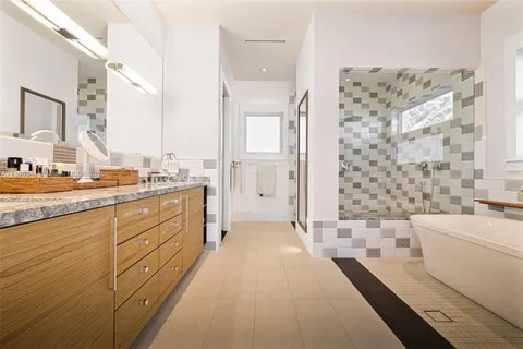 a spacious bathroom with a double vanity sink toilet mirror and bathtub