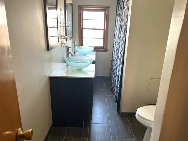 a bathroom with a sink toilet and window
