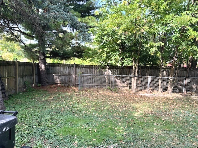15240 Ashland Avenue Harvey, IL 60426 - Photo 27 of 27 a backyard with wooden fence and a large tree