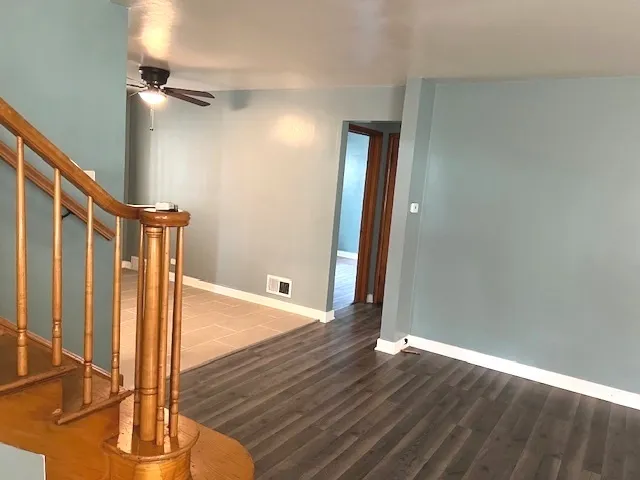 a view of a hallway with wooden floor and staircase