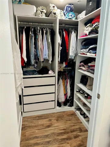 a view of walk in closet with clothes and shoes