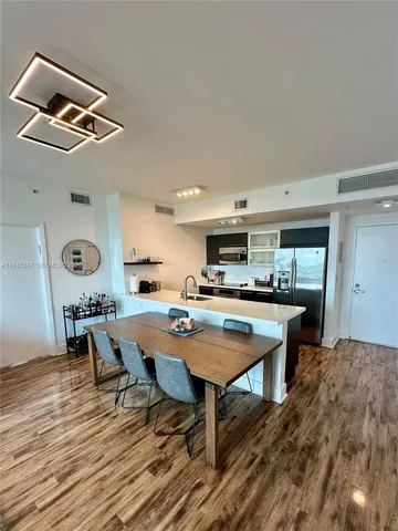 a room with stainless steel appliances kitchen island a table and chairs in it