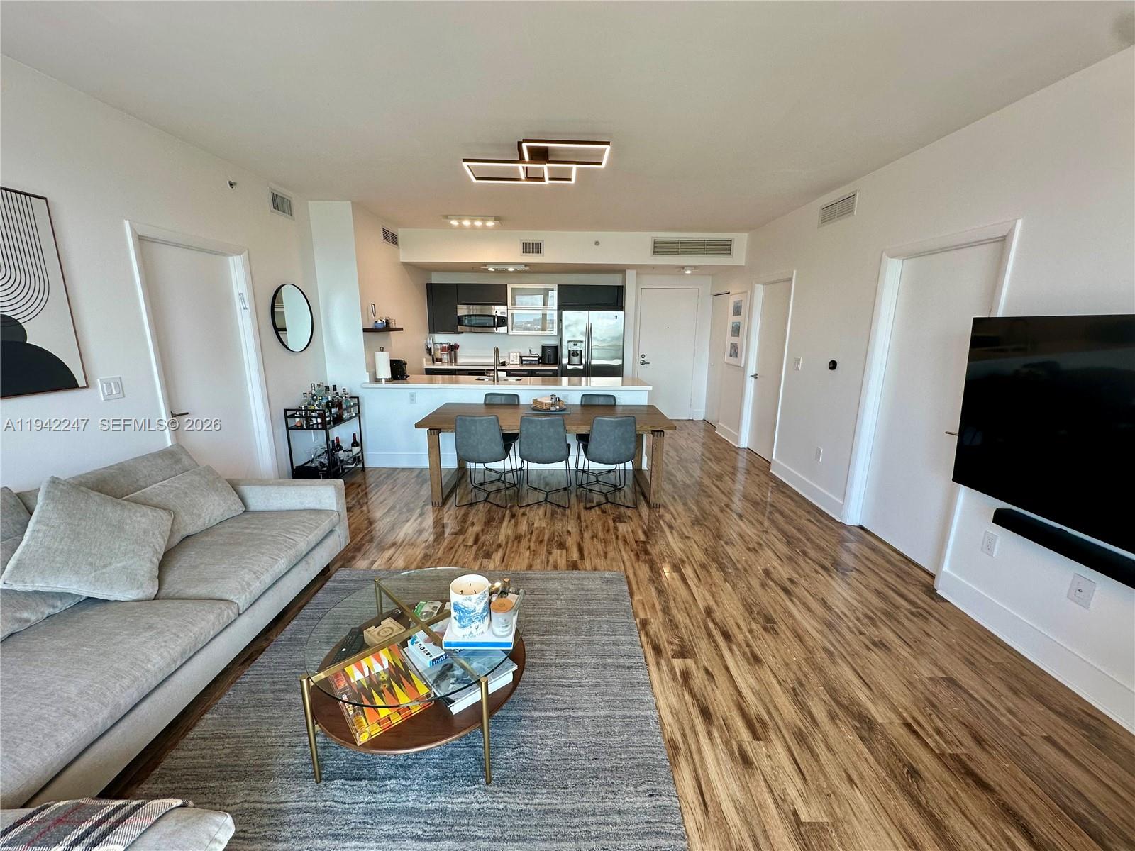 90 Southwest 3rd Street, Unit 2306 Miami, FL 33130 - Photo 3 of 29 a living room with furniture and a flat screen tv