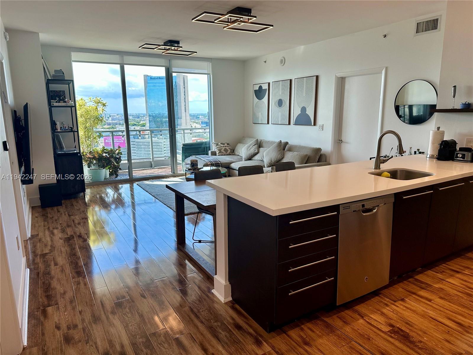 90 Southwest 3rd Street, Unit 2306 Miami, FL 33130 - Photo 4 of 29 a kitchen with a stove a sink and a dining table with wooden floor