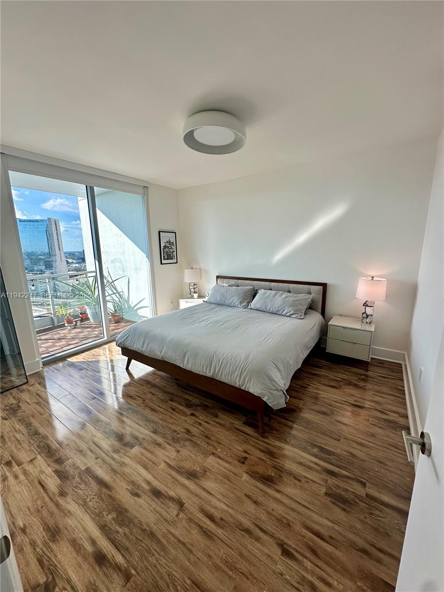 90 Southwest 3rd Street, Unit 2306 Miami, FL 33130 - Photo 7 of 29 a bedroom with a bed and wooden floor