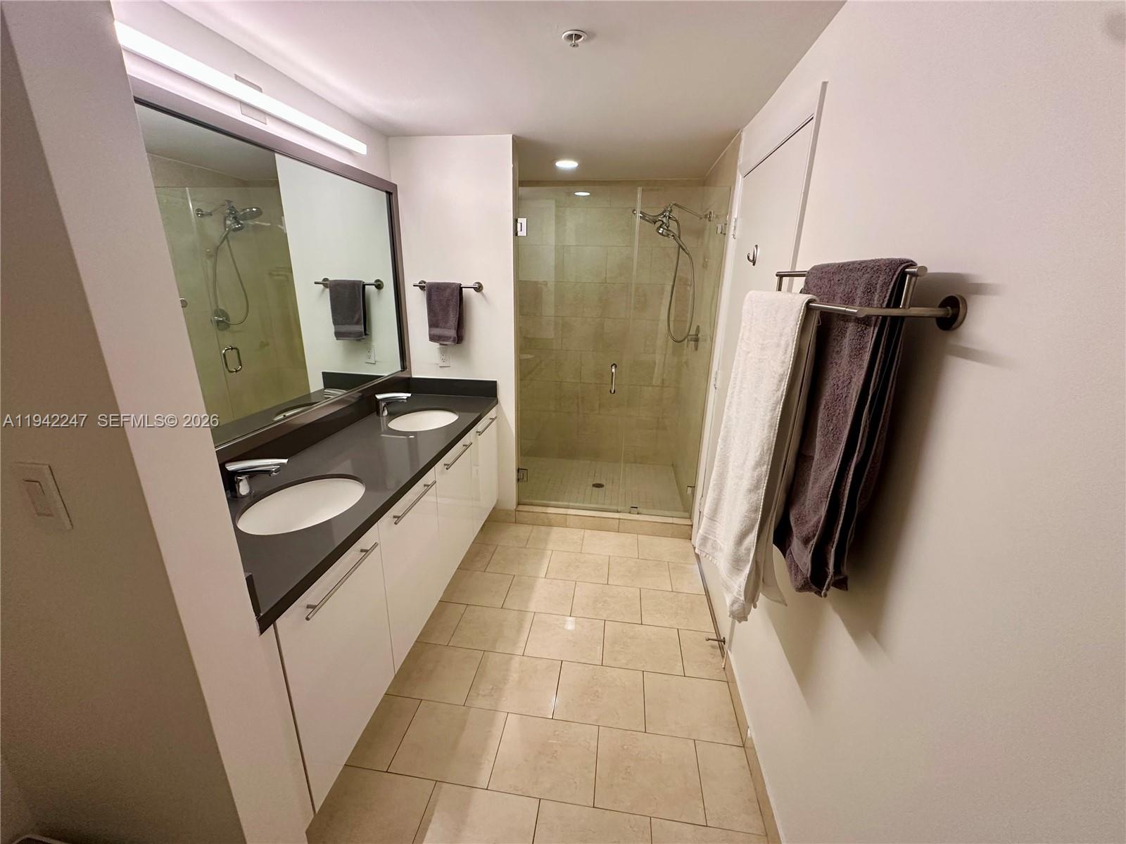 90 Southwest 3rd Street, Unit 2306 Miami, FL 33130 - Photo 10 of 29 a bathroom with a granite countertop sink and a mirror