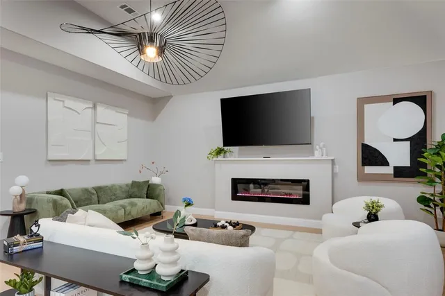 a living room with furniture a fireplace and a flat screen tv