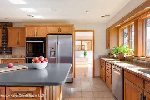 a kitchen with stainless steel appliances a sink and large window