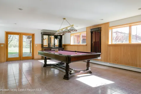 a room with pool table and windows
