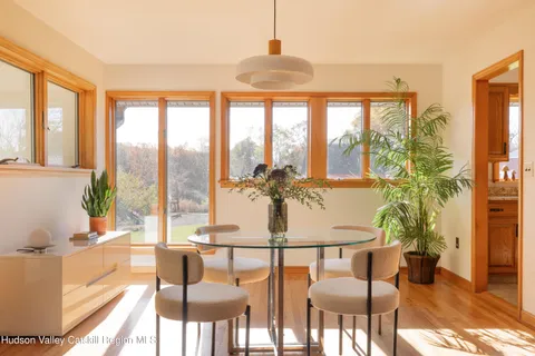 a view of a dining room with furniture large windows and wooden floor