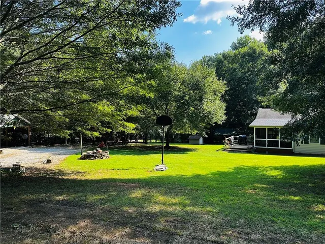 a view of yard with swimming pool and green space