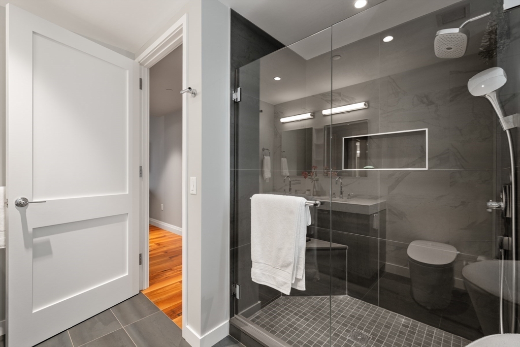 300 Pier 4 Blvd., Unit 7G Boston, MA 02210 - Photo 20 of 39 a bathroom with a sink a toilet and a mirror