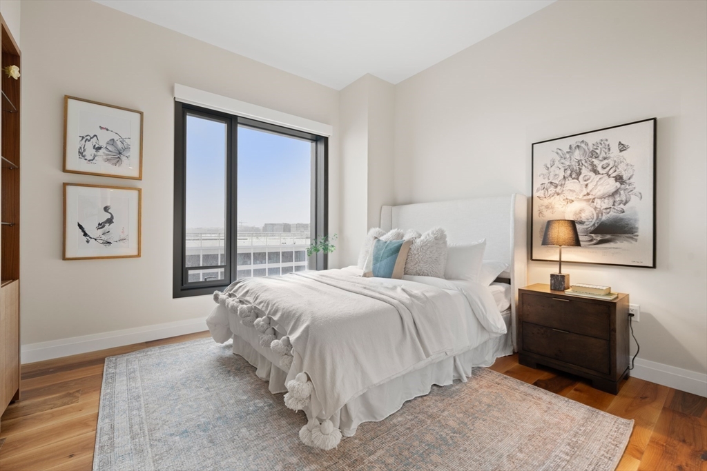 300 Pier 4 Blvd., Unit 7G Boston, MA 02210 - Photo 21 of 39 a spacious bedroom with a bed and a large window