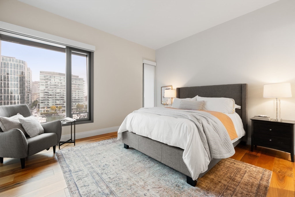 300 Pier 4 Blvd., Unit 7G Boston, MA 02210 - Photo 23 of 39 a spacious bedroom with a bed and glass window