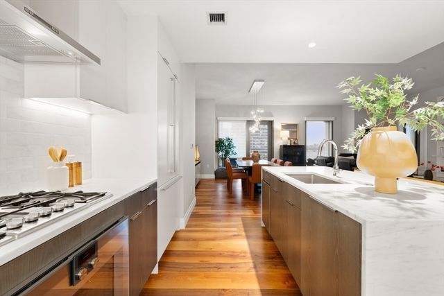 a dining hall with granite countertop a stove and white cabinets