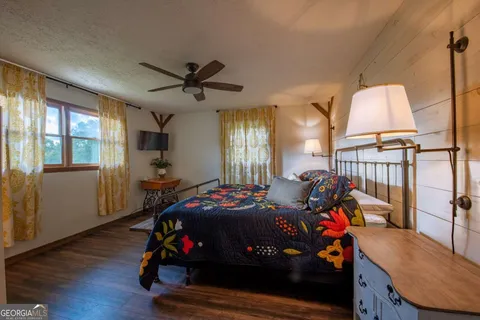 a bedroom with a bed and a ceiling fan