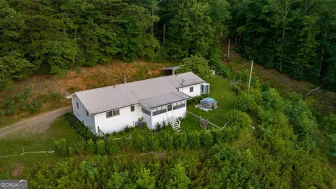a aerial view of a house next to a big yard and large trees