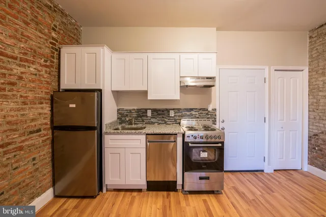 a kitchen with a refrigerator and a stove