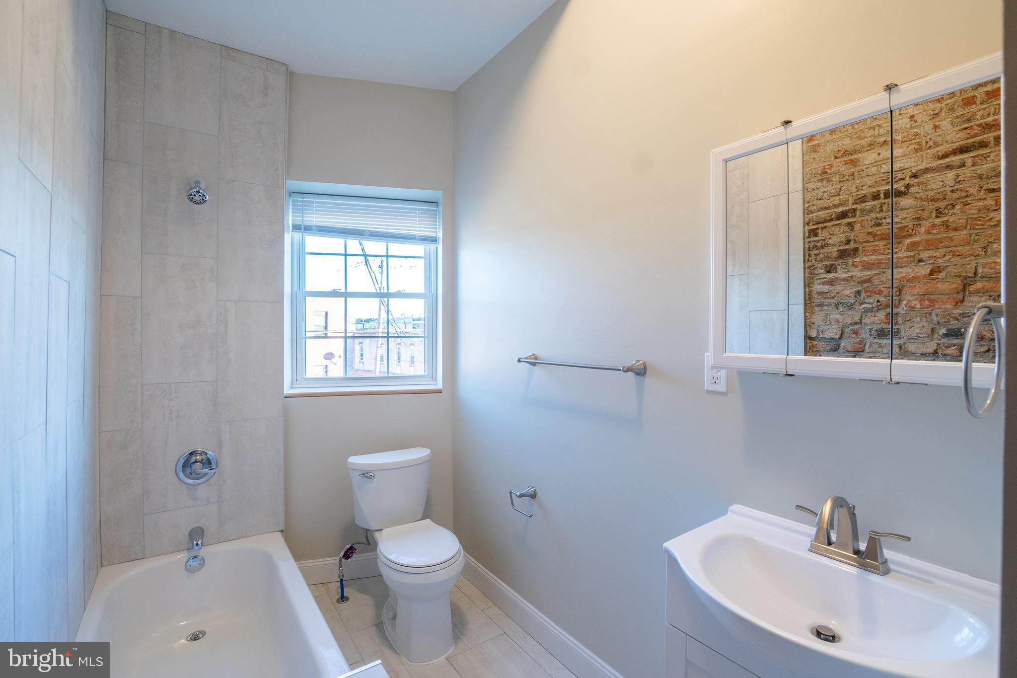 1126 East Passyunk Avenue, Unit 3 Philadelphia, PA 19147 - Photo 8 of 9 a bathroom with a sink a toilet and shower