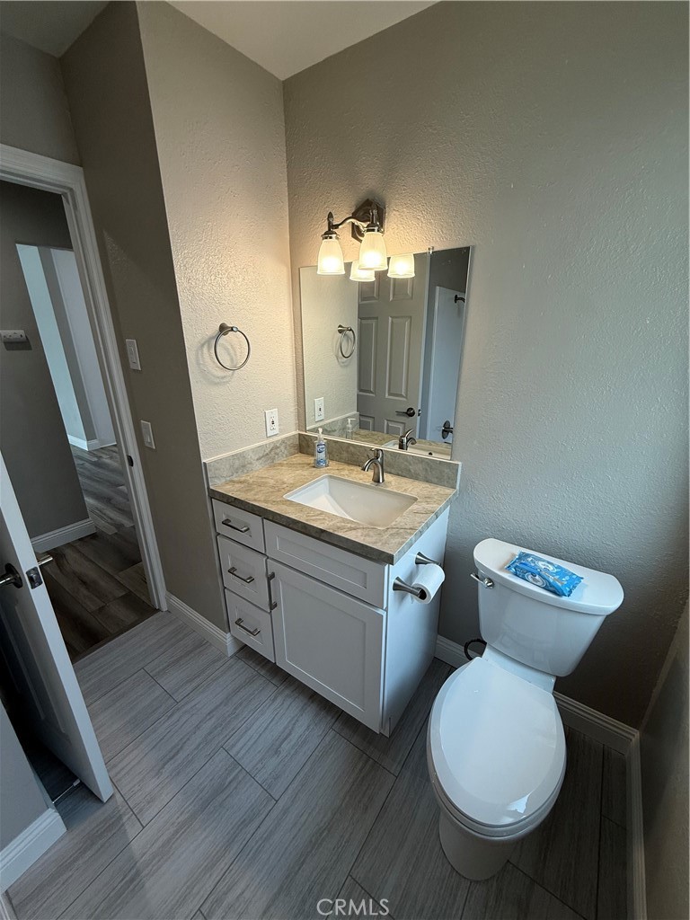 596 Opal Avenue Hemet, CA 92543 - Photo 19 of 30 a bathroom with a granite countertop toilet sink and mirror