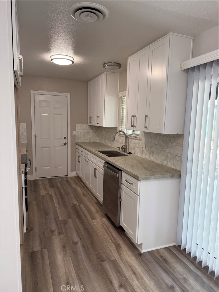 596 Opal Avenue Hemet, CA 92543 - Photo 7 of 30 a kitchen with stainless steel appliances granite countertop a stove a sink and a refrigerator