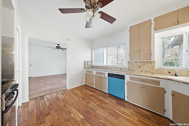 a kitchen with a sink cabinets stainless steel appliances and a window