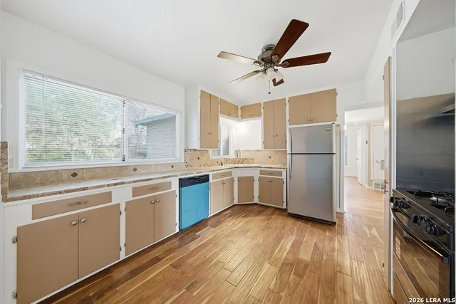 a kitchen with a refrigerator a stove a sink and a window