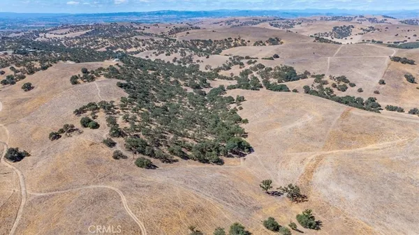 a view of a lush green outdoor space with a swimming pool and valleys in the background