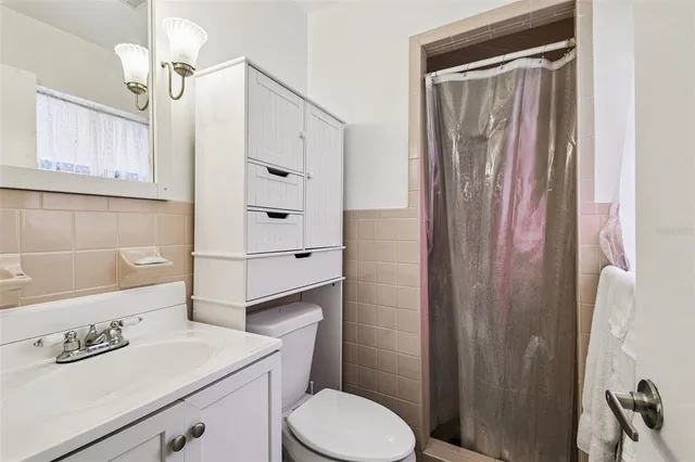 a bathroom with a sink a toilet a mirror and shower