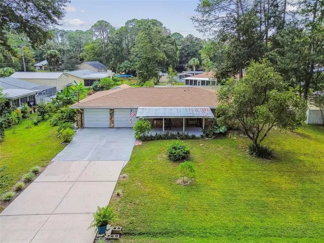 a aerial view of a house with swimming pool and large trees